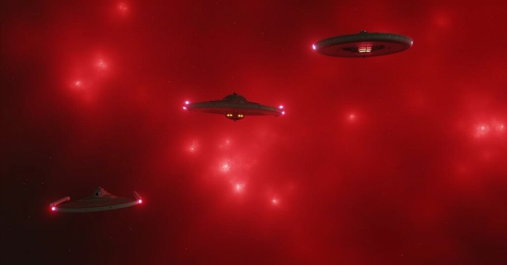 Federation, Klingon and Romulan ships in a three-way stand-off in a red nebula in Star Trek Fleet Command